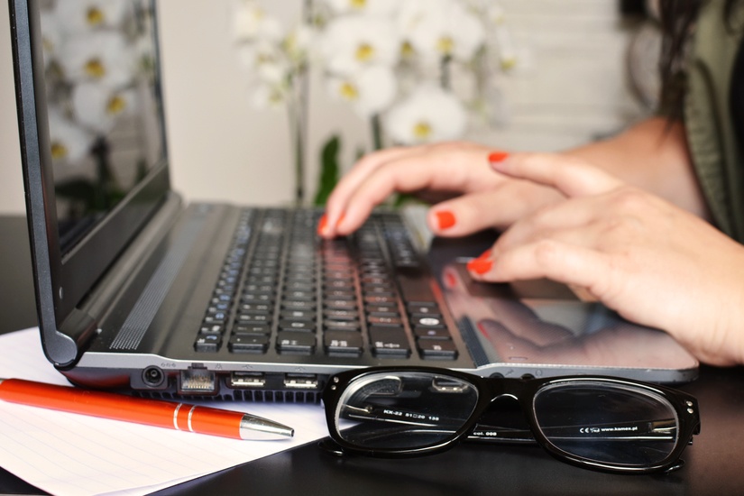 Hands typing on a laptop