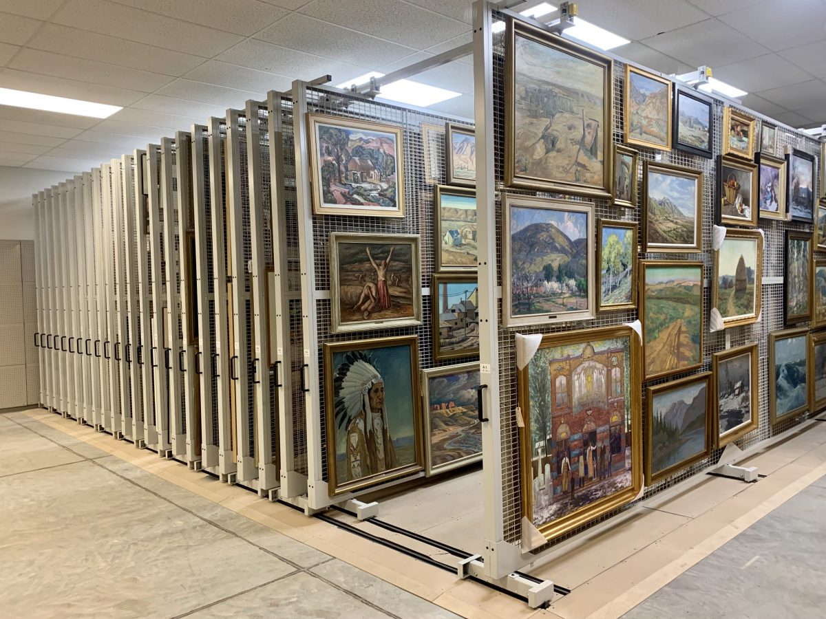 Framed artworks are neatly displayed on vertical storage racks.