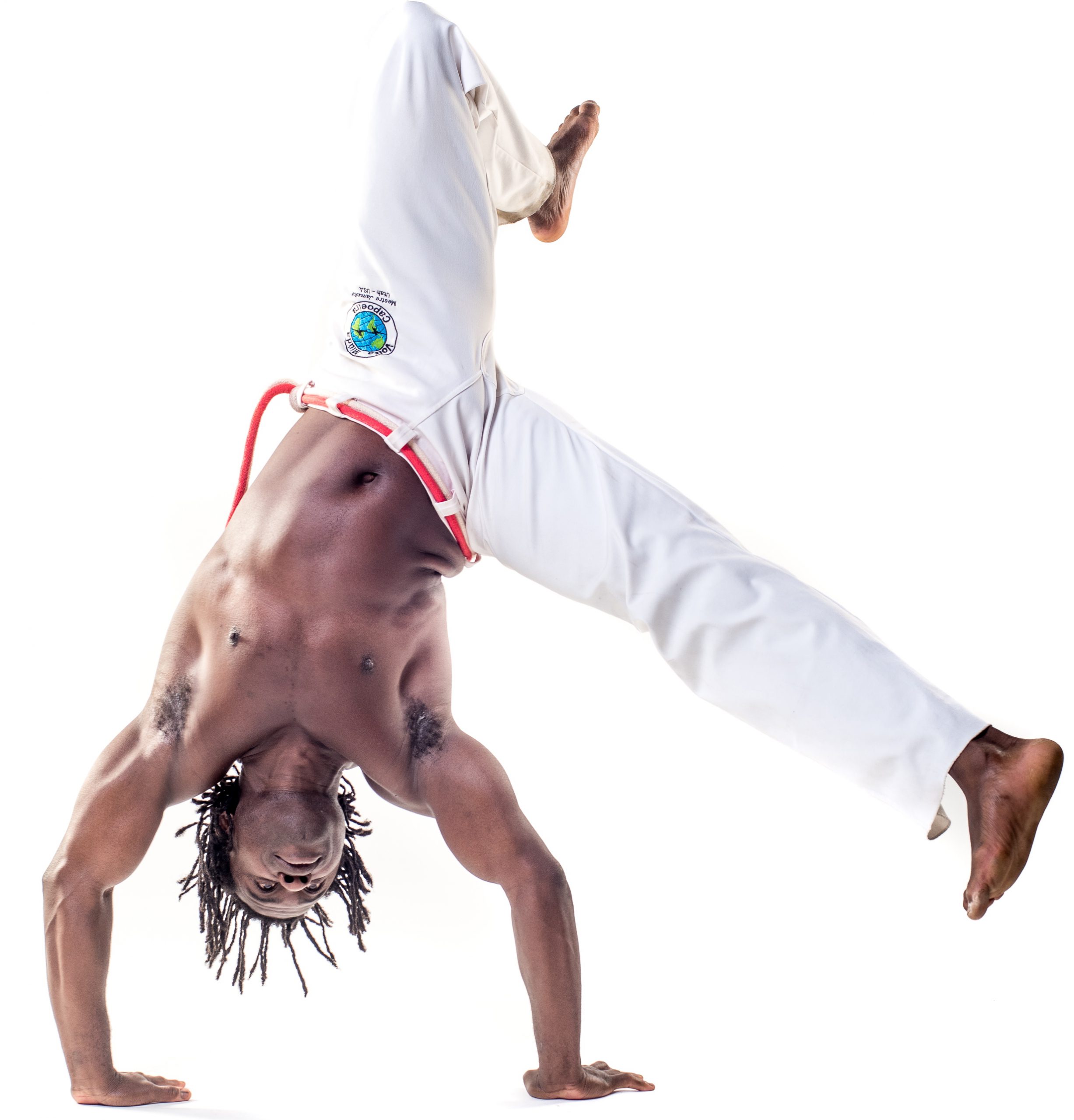 A photo of a shirtless Black man wearing white mans, doing a handstand.
