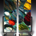 Colorful glass artwork held by metal stands.