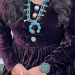 A woman displaying turquoise and silver jewely.