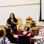 A woman speaking to a classroom of young children.