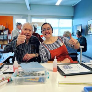 Artist and teacher giving a thumbs up during a creative aging class