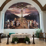 A large mural on a church wall of the crucifixion of Jesus.