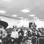 a black and white photo of author Jared Quan in a crowded hotel convention room
