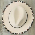 wide brimmed white hat with intricate beadwork on the brim