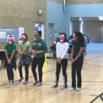 5 dancers with red masks in a school gym