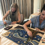 Workshop participants creating chalk drawings at a table