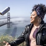 Teaching Artist Tracy Williams tossing a spray paint can in the air
