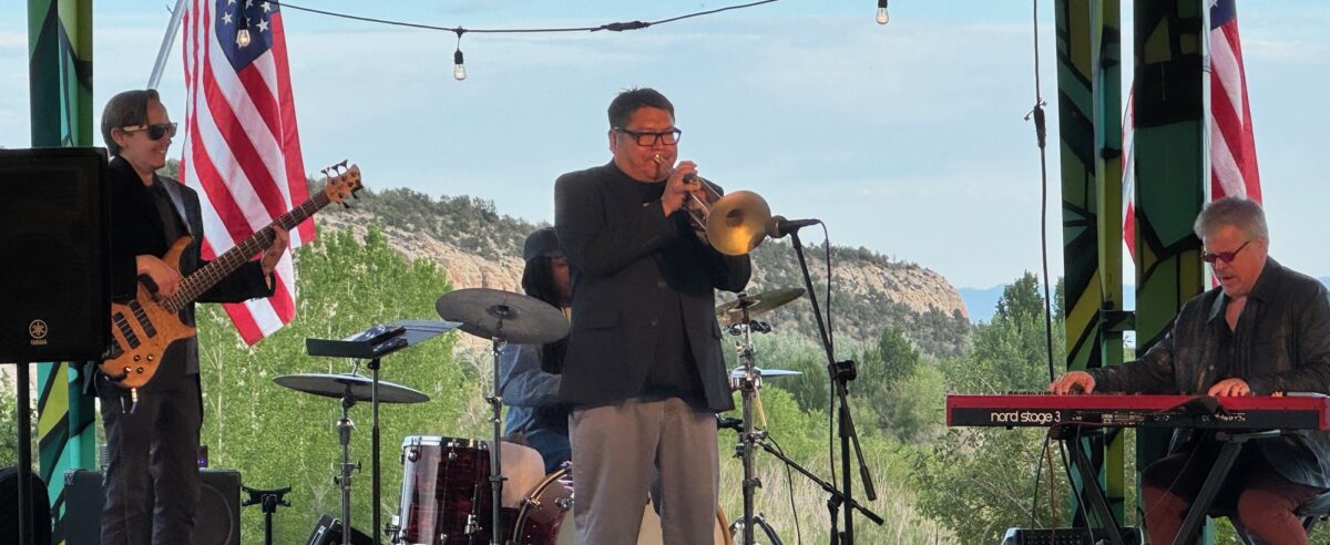 A jazz trio performs at an outdoor venue.