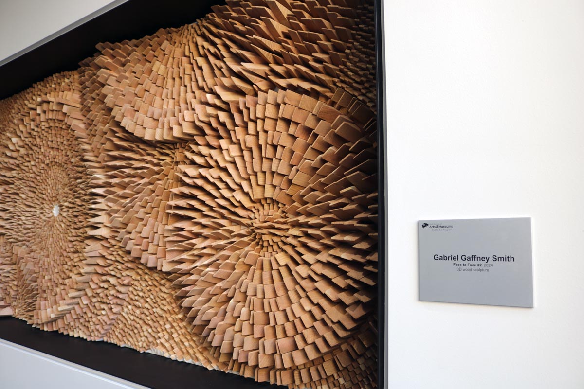 An intricate wood artwork next to its plaque.