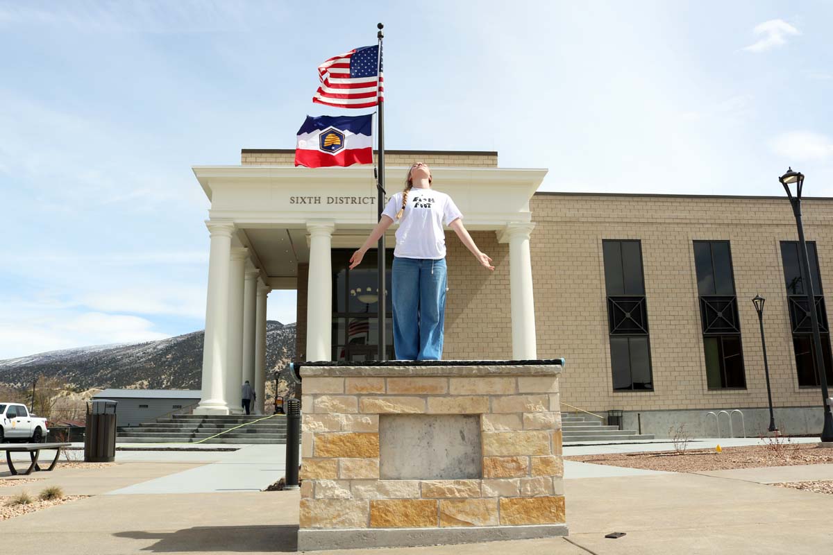 An empty pedestal in front of a courthouse building.
