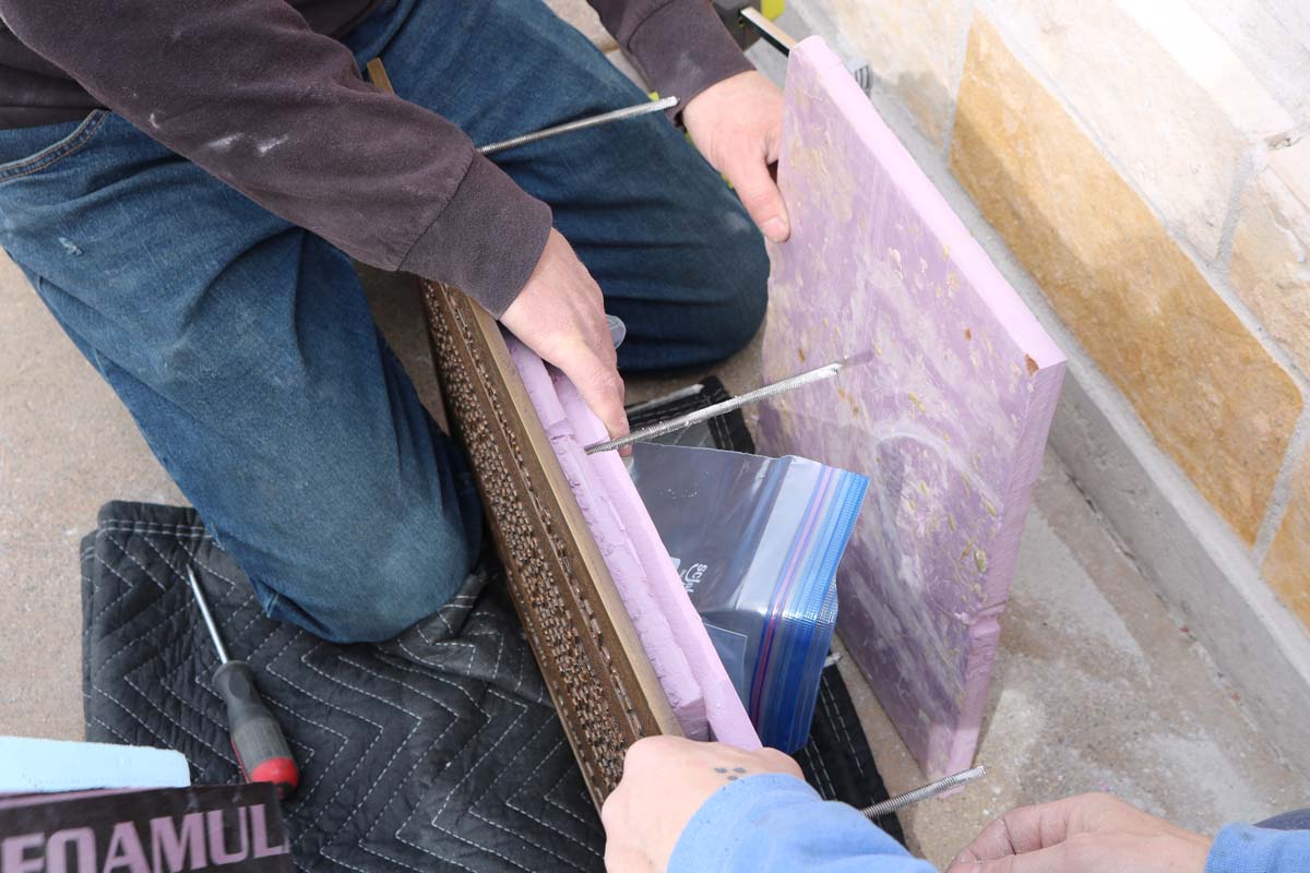 Two men preparing a plaque for installation.