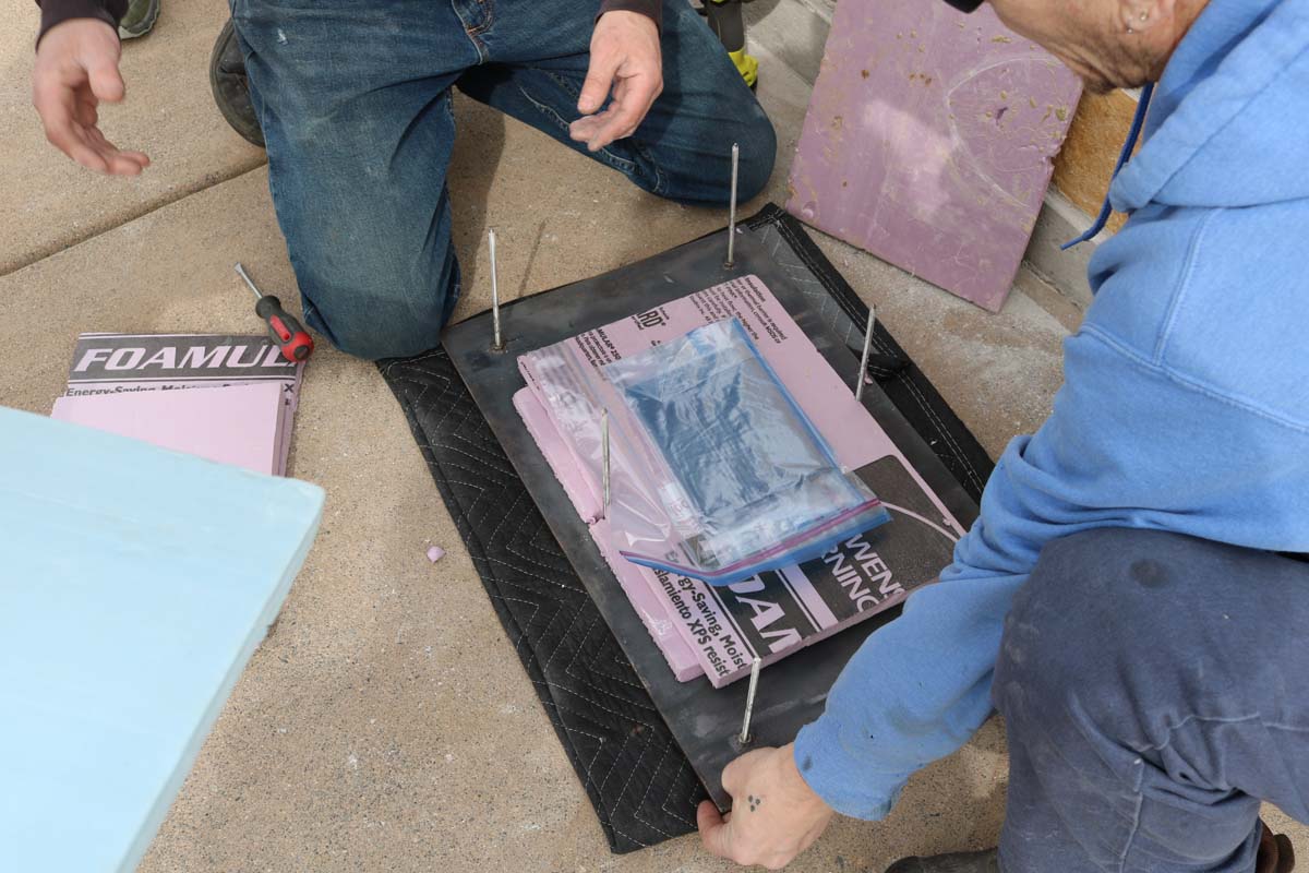 Two men preparing a plaque for installation.