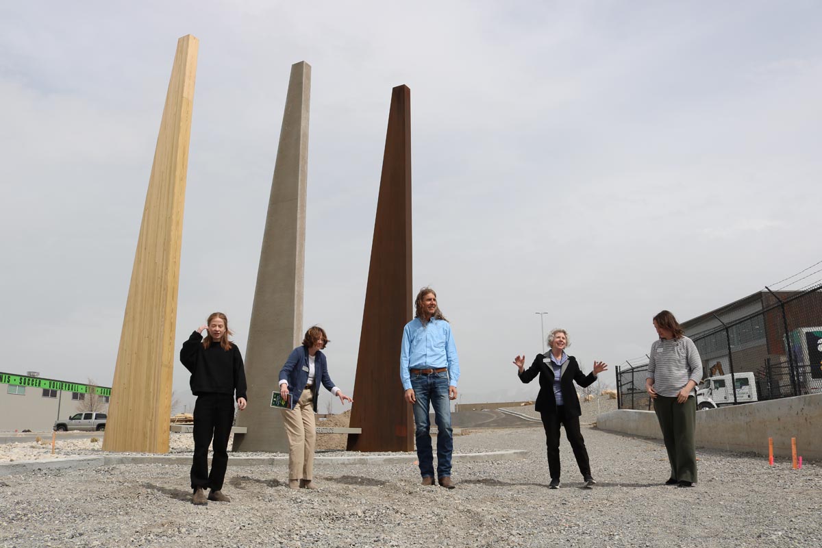 Five individuals in front of an outdoor art installation.