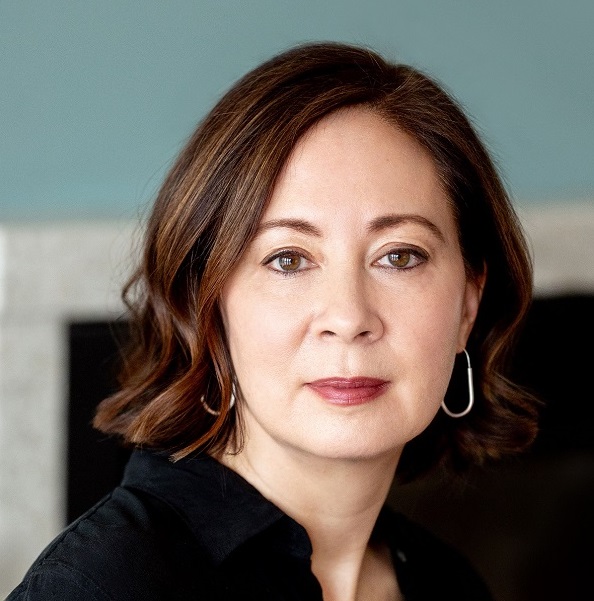 A woman with brown hair and brown eyes wearing a black shirt.