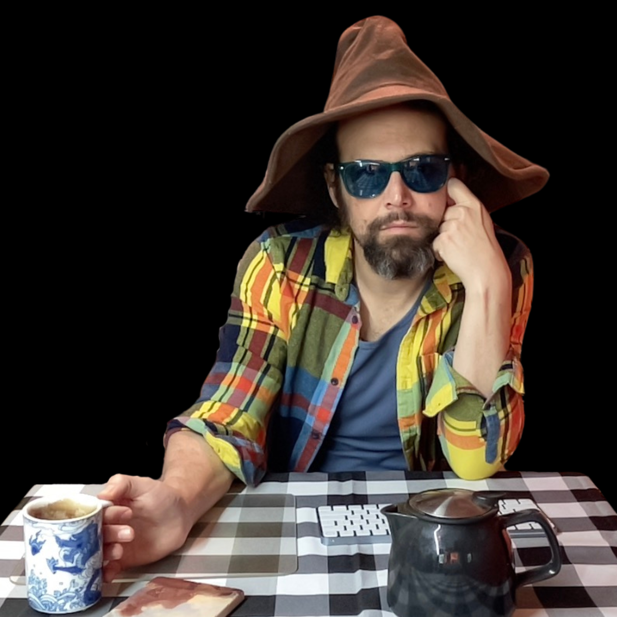 A man wearing sunglasses, a floppy hat, and a plaid shirt, holding a mug of tea.