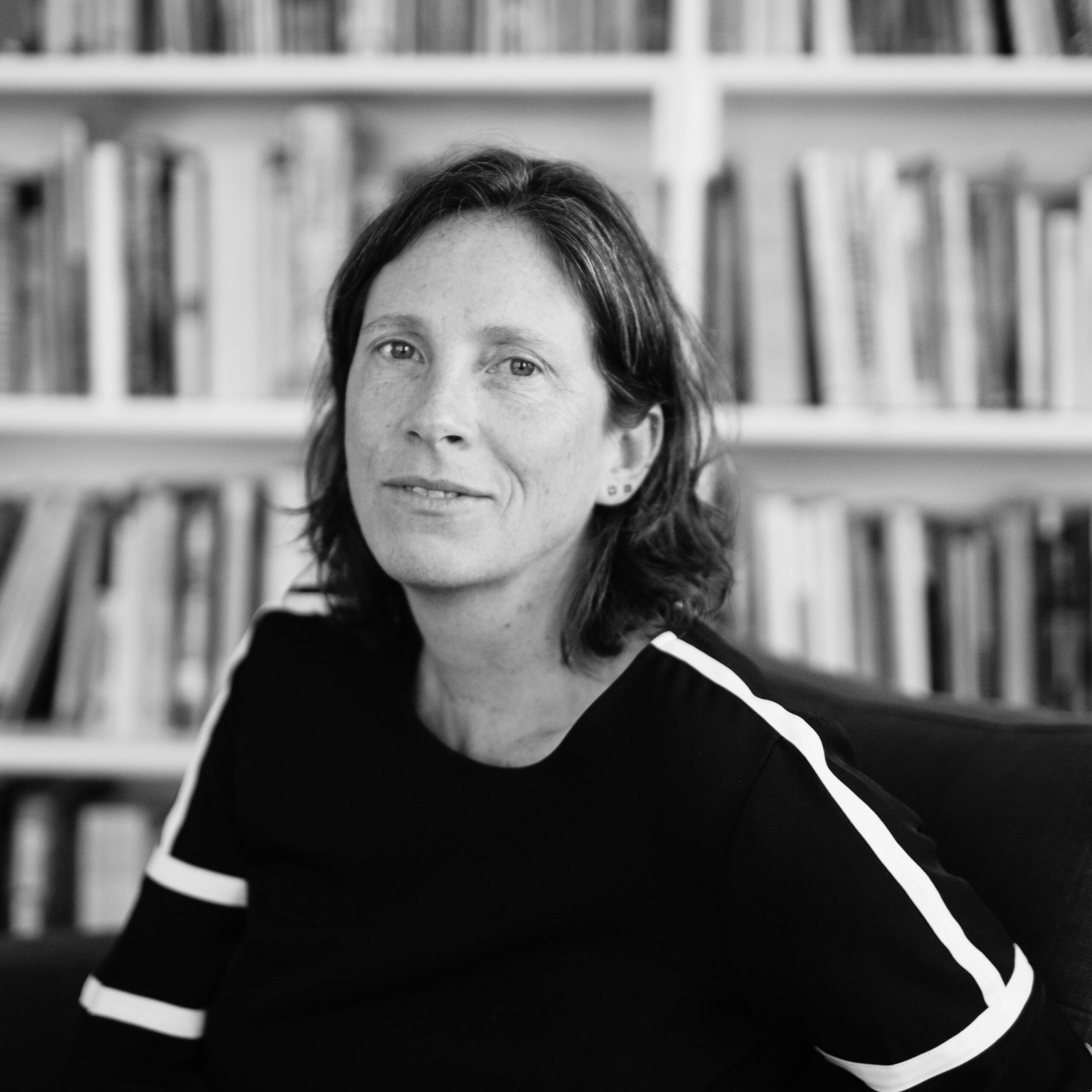 A woman with brown hair wearing a black-and-white top.