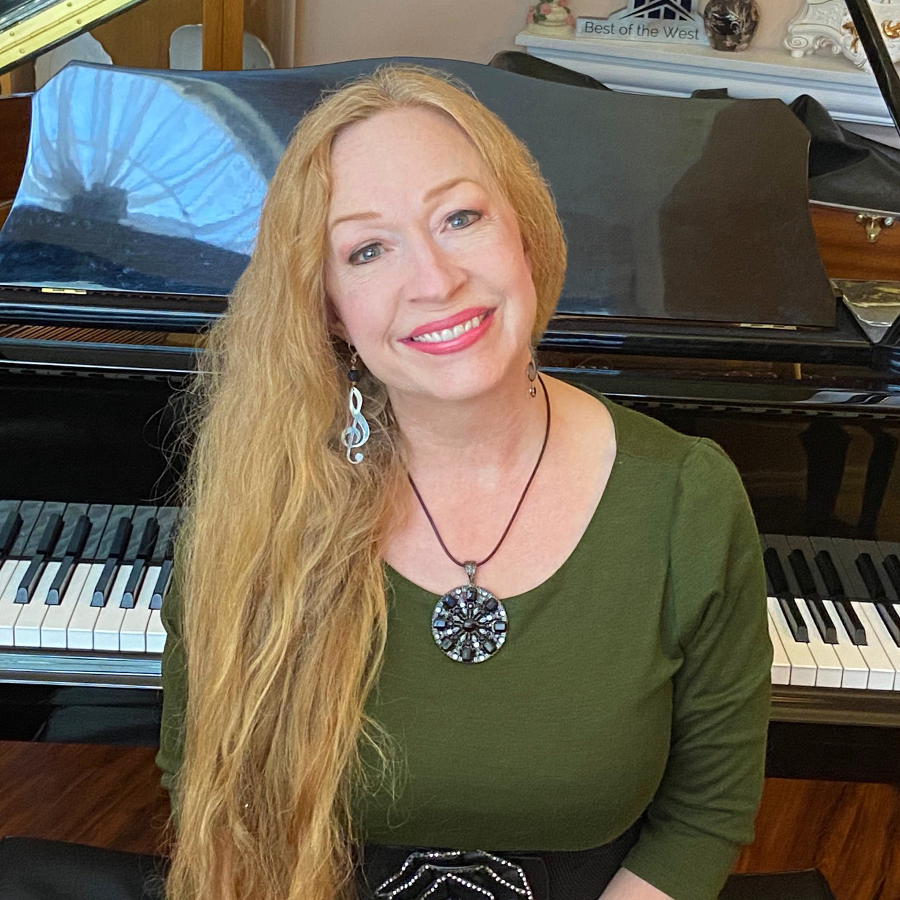 A woman with long blonde hair wearing a green shirt.
