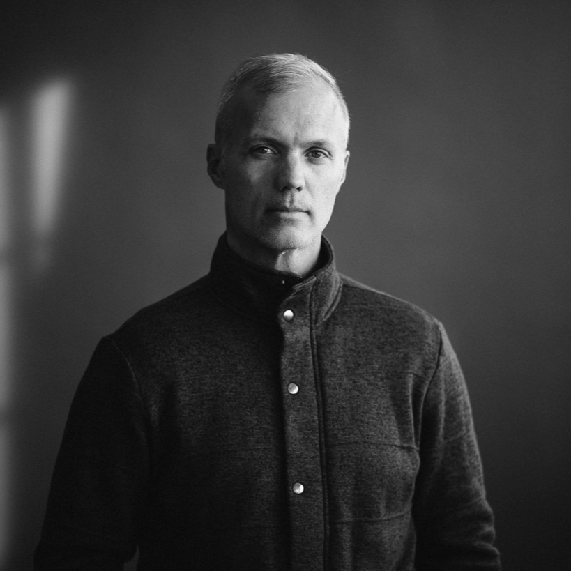 A man with light hair and a dark shirt.