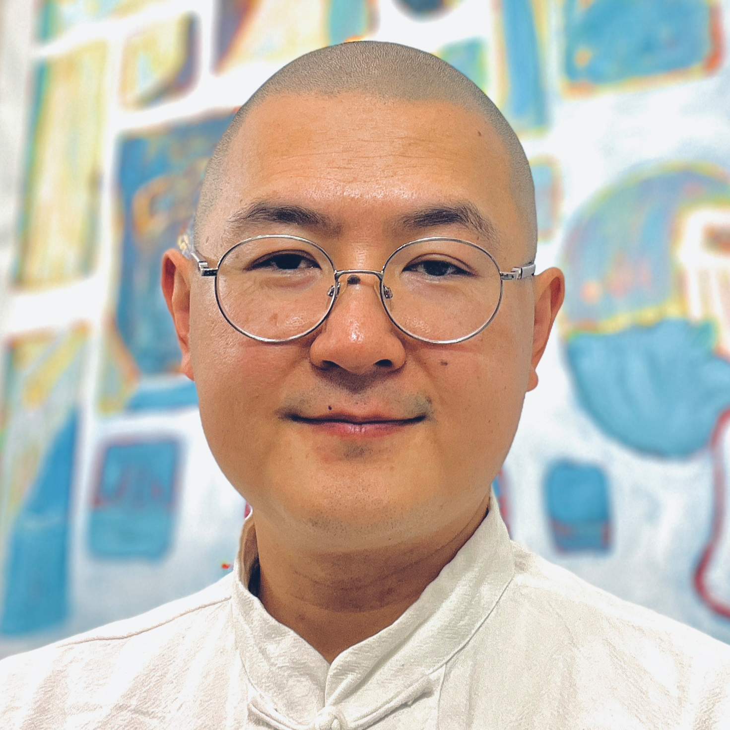 A bald man wearing glasses and a white shirt.